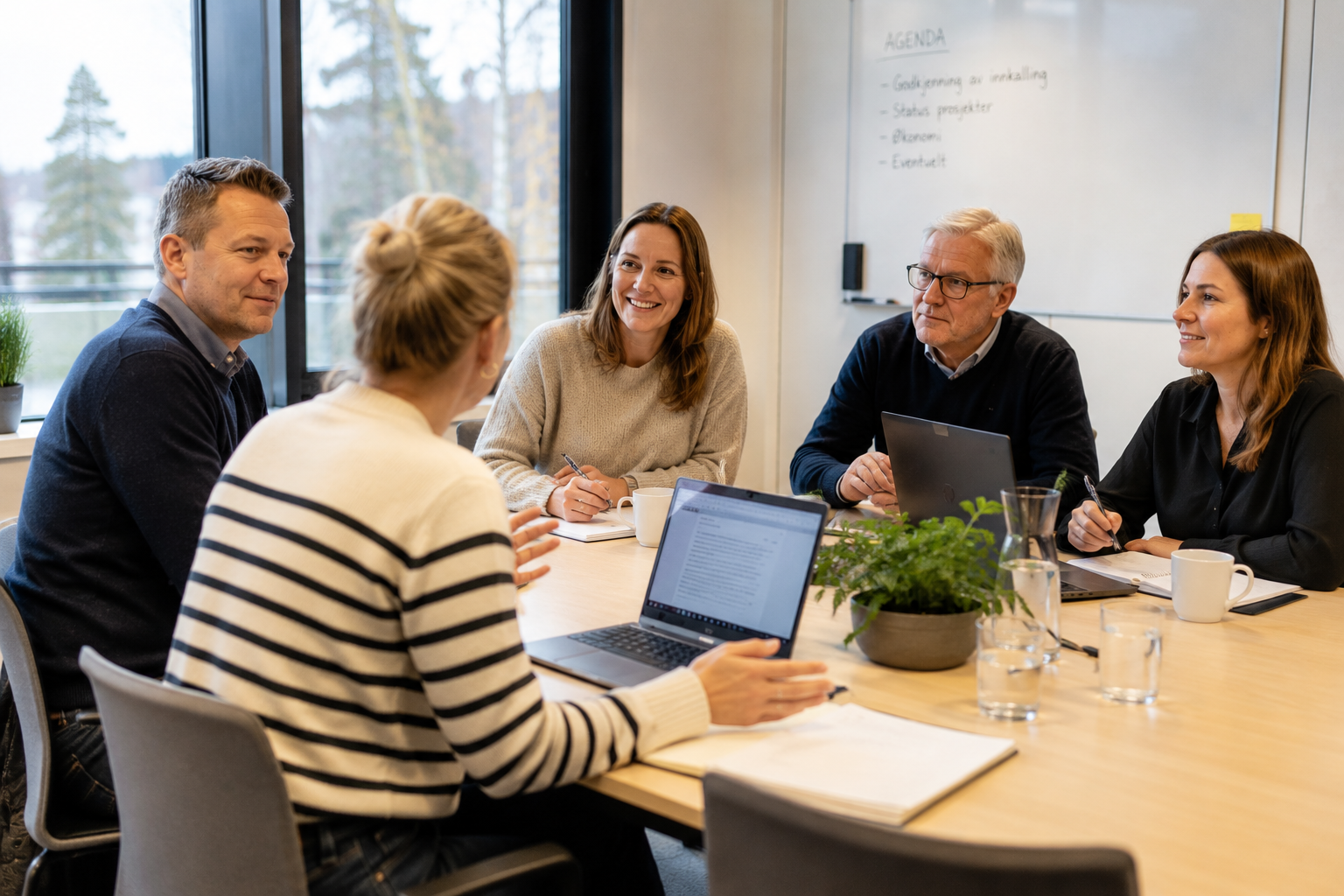 Kvinner og menn samlet rundt et bord i et styremøte.